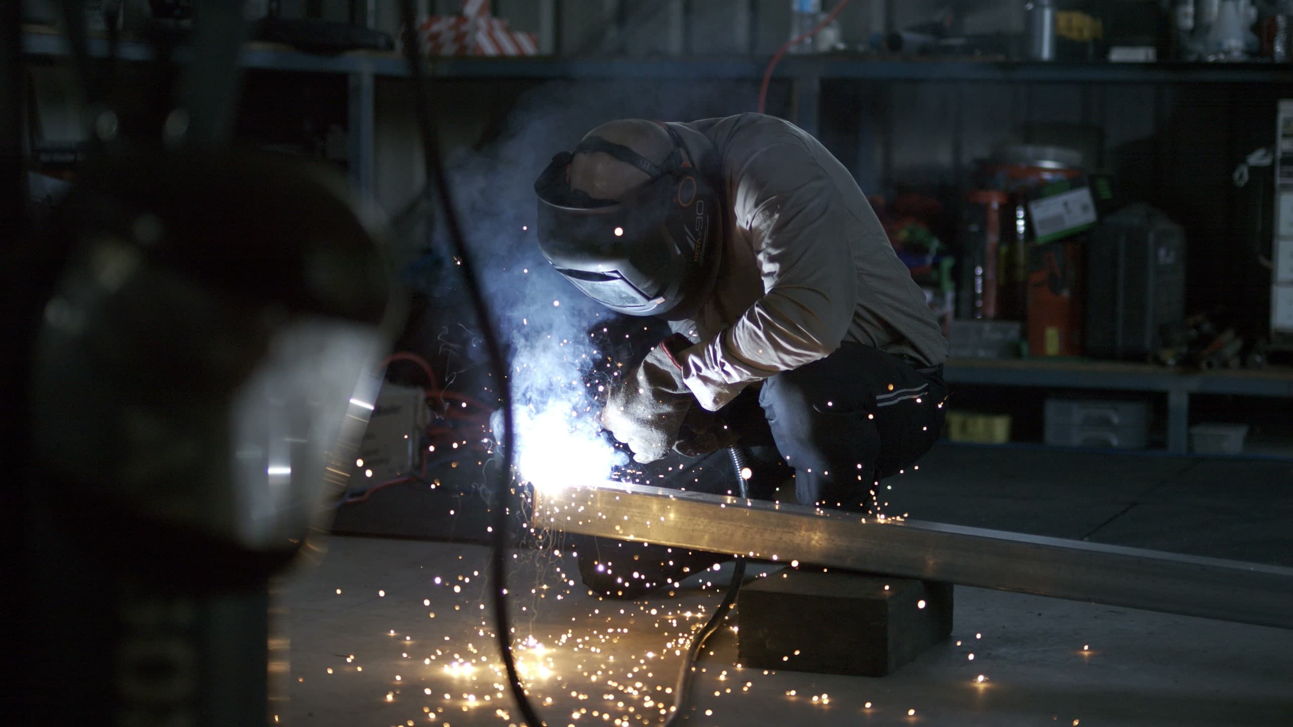 Welding sparks fly across the frame on set for the Thorzt commercial shoot.